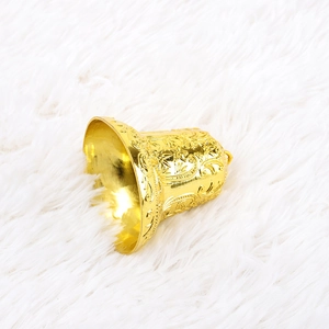 Golden Christmas bell with embossed floral patterns on white fluffy background