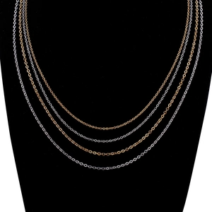 Close-up of gold and silver stainless steel O-chains displayed on black velvet bust