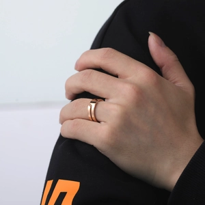 Close-up of a rose gold geometric open ring worn by a model in a minimal setting