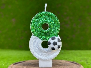 Vue macro de bougie d'anniversaire numéro 8 pailletée verte avec petit décor de football