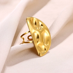 Detailed close-up of golden stainless steel ring with a hammered lava texture disk