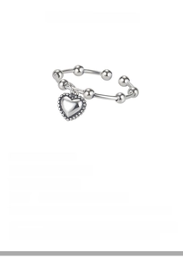 Macro detail of S925 sterling silver beaded ring with vintage heart charm pendant