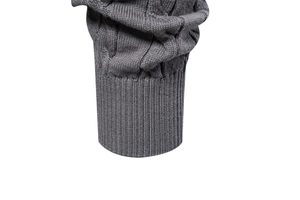Detail of grey knitted sweater sleeve featuring cable knit texture and elastic ribbed cuff
