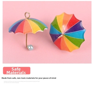 Macro shot of colorful rainbow mini umbrella charms with gold hooks for DIY jewelry