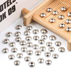 Polished silver stainless steel spacer beads for DIY jewelry making on bamboo tray
