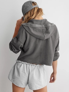 Rückansicht eines dunkelgrauen Cropped-Hoodies mit passender Kappe und Streifenshorts