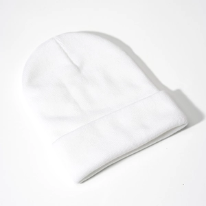 Detailed close-up of a white ribbed knit beanie hat featuring a classic folded cuff design