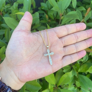 18K gold plated hip hop cross necklace with micro-pave zircons held outdoors