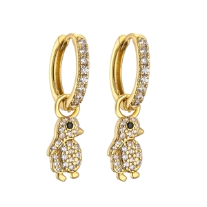 Detail of gold penguin hoop earrings featuring sparkling pave white zircon and black gemstone eyes