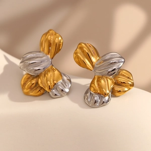 Detailed macro view of two-tone petal earrings with brushed 18K gold and silver textures