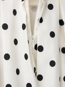 Gros plan détaillé du tissu à pois blancs et de la fermeture éclair invisible de qualité