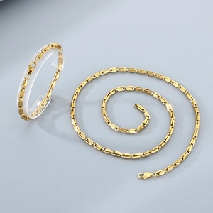 Close-up of gold-plated U-shaped link chain necklace and bracelet set in stainless steel