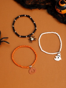 Detailed view of Halloween beaded bracelets with spider, ghost, and pumpkin charms