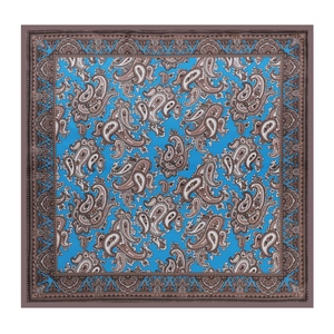 Flat lay of blue square silk scarf featuring classic brown and white paisley floral patterns
