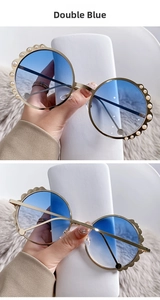 Detailed view of round sunglasses with gold metal frame and white pearl embellishments