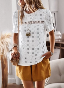 Detail shot of white top featuring delicate hollow-out embroidery and lace trim details