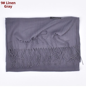 Close-up of heather gray cashmere scarf featuring fine woven texture and soft fringed edges
