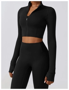 Détail de l'ensemble de yoga noir avec poignets passe-pouce et haut de sport à demi-zip