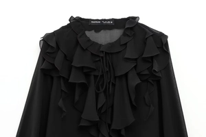 Nahaufnahme der schwarzen Schluppenbluse aus Chiffon mit Volants und eleganten Rüschendetails