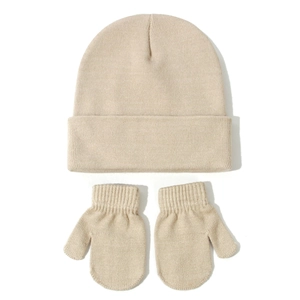 Flat lay detail of beige knitted baby winter hat and matching mittens set on white background
