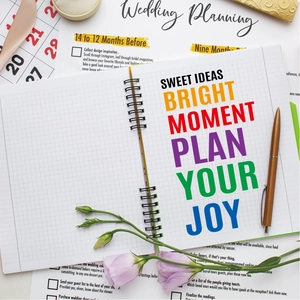 Floral wedding planner notebook with Sweet Ideas slogan on a flat lay desktop