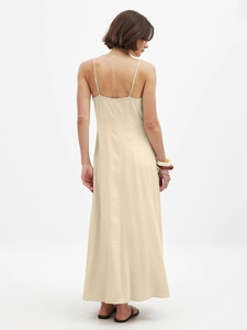 Back view of a beige cotton maxi dress featuring thin straps and elegant open-back detail