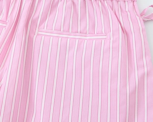 Detail view of pink and white striped cotton fabric and pocket stitching on casual shorts