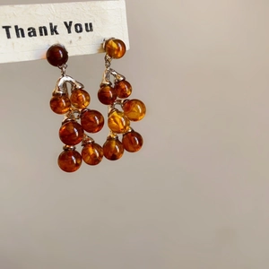 Detailed view of amber spherical beaded earrings with vintage silver metal links