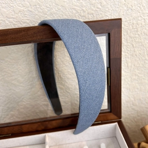 Gros plan d'un serre-tête en denim bleu scintillant sur une boîte en bois rétro