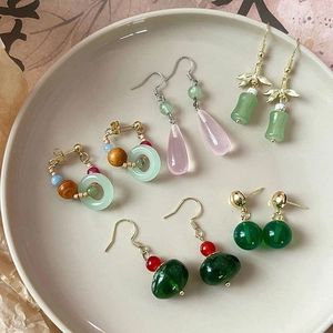 Bamboo style earrings set with green beads and tassels in traditional Chinese aesthetic