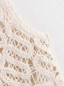 Gros plan détaillé sur la maille crochetée élégante et le motif ajouré crème texturé