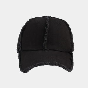 Detail of black baseball cap with distressed frayed edges and vertical stitching accents