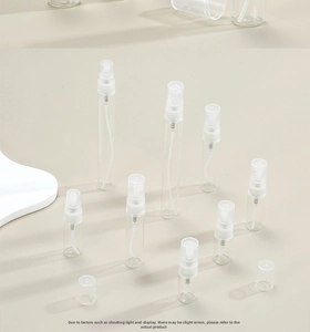 Detailed view of clear glass perfume spray bottles in various sizes with fine mist nozzles