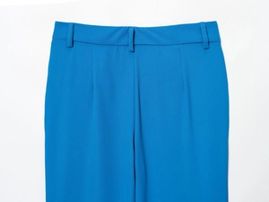 Détail du pantalon bleu vif montrant la structure de la taille et la texture du sergé