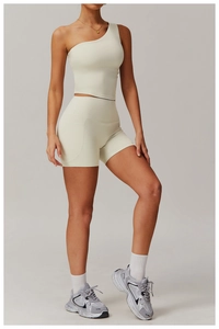 Detailed side view of beige one-shoulder yoga vest and high-waisted shorts with pockets