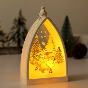 Detail of white Christmas lantern with cartoon elk silhouette and warm yellow light