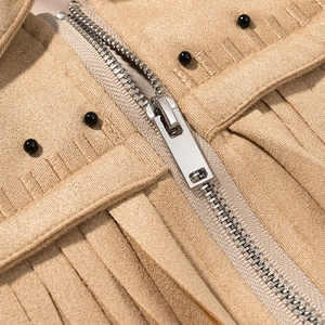 Makro-Detail von Metallreißverschluss und schwarzen Perlen an khakifarbener Kunstlederjacke