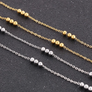 Minimalist 18K gold and silver stainless steel bead chain necklaces set on dark background