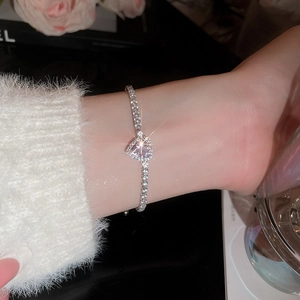 Close-up of heart-shaped bracelet with pink crystal and white zircon pavé setting