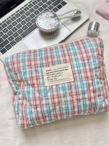 Quilted checkered makeup bag in pastel colors with secure zipper and woven label