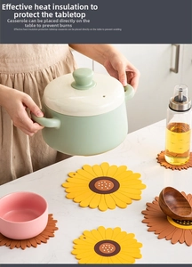 Detailed view of sunflower silicone trivet protecting table from a hot green pot
