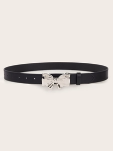 Detail of silver bow-shaped metal buckle on a black leather belt with holes