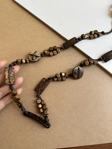 Detail of bohemian waist chain featuring dark brown acrylic beads on woven rope