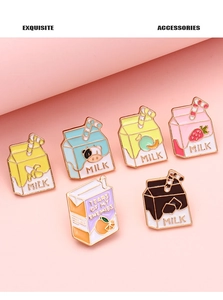 Detailed set of six enamel milk box brooches in vibrant colors on a soft pink background