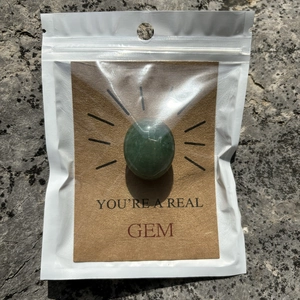 Macro shot of a polished green crystal stone fixed on a You're a Real Gem gift card