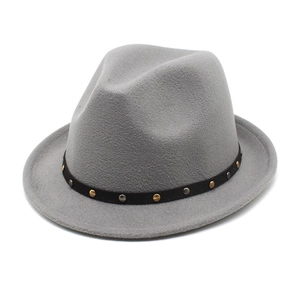 Detail of wool fedora hat featuring black band with gold and silver round studs