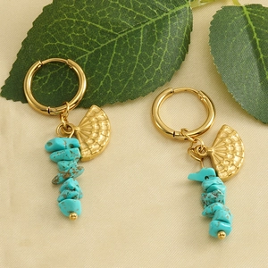 Bohemian gold stainless steel fan earrings with blue turquoise stones on fabric background