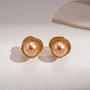 Macro shot of champagne pearl earrings with crystal-encrusted gold-tone metal borders
