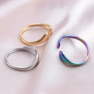 Detailed view of adjustable stainless steel rings in gold, silver, and rainbow finishes
