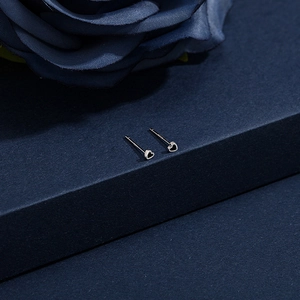 Macro shot of minimalist silver heart studs with black filling and S925 silver finish